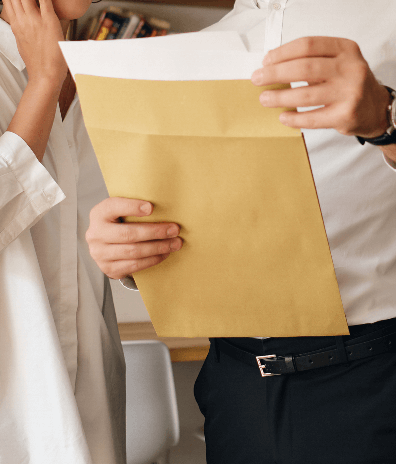 Person opening a large yellow envelope.