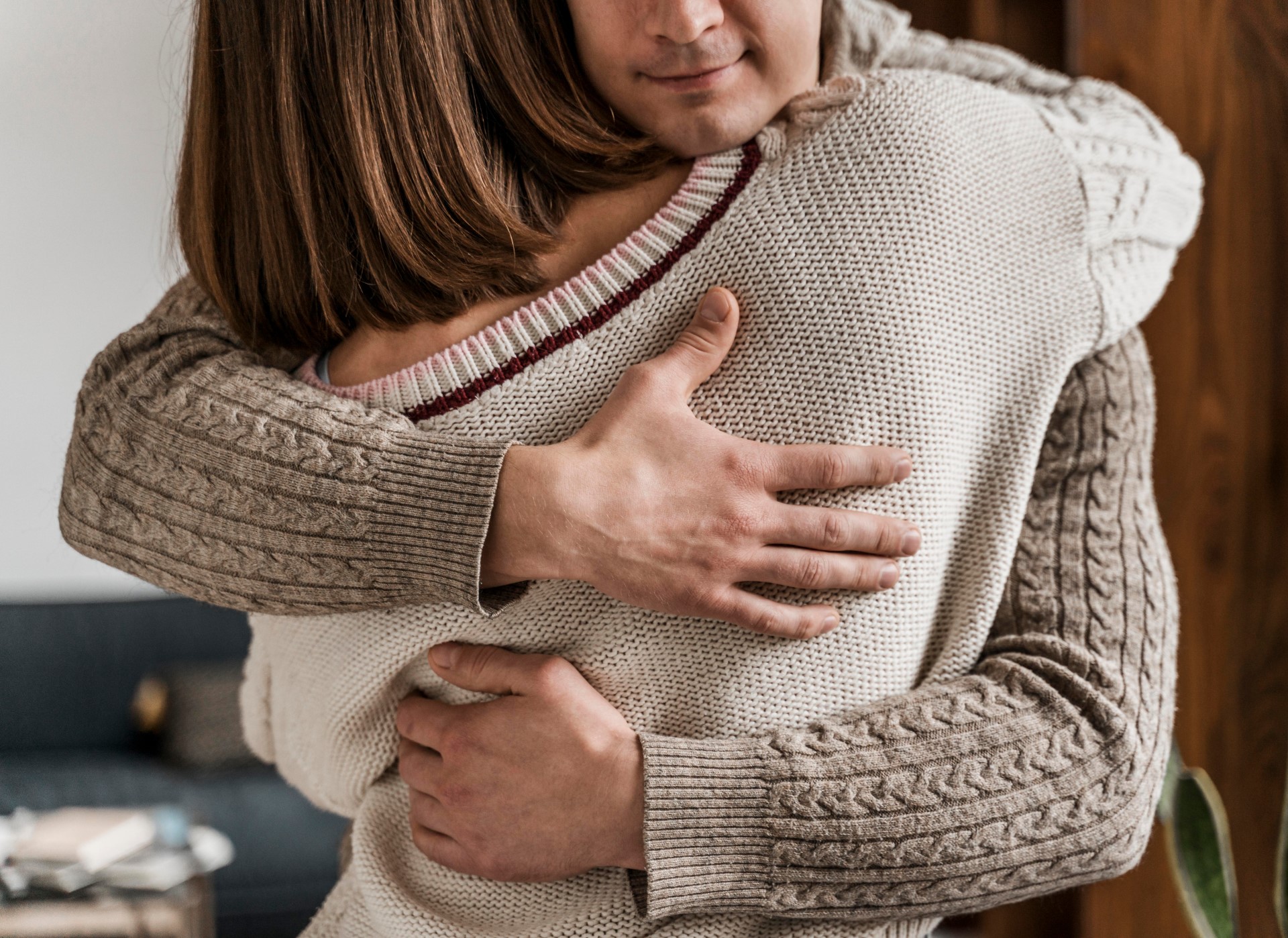 Two people sharing a warm embrace indoors.